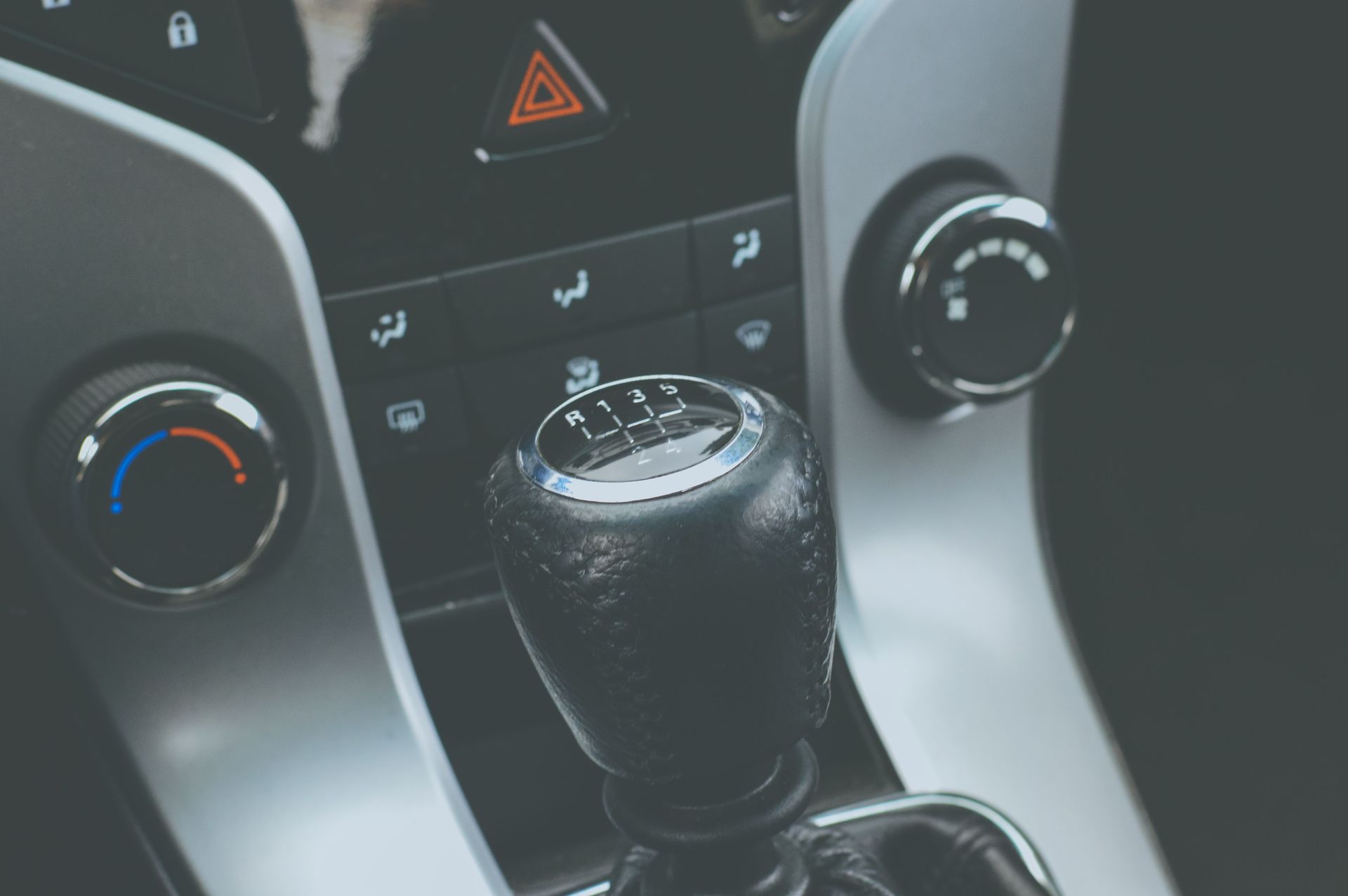 Detailed view of a manual gear shift knob and car console interior.